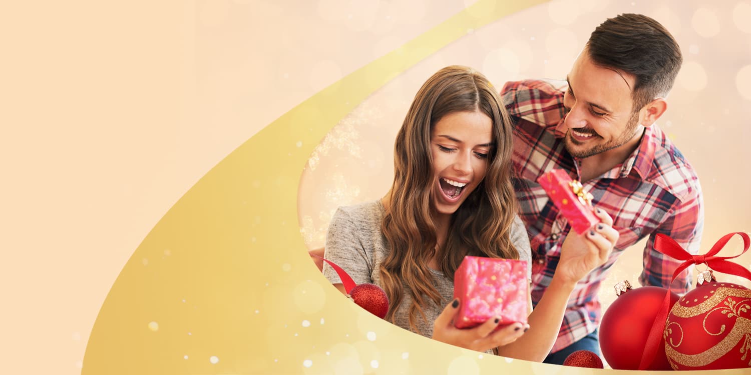 Giovane coppia che apre un buono regalo per le lezioni di danza di Arthur Murray